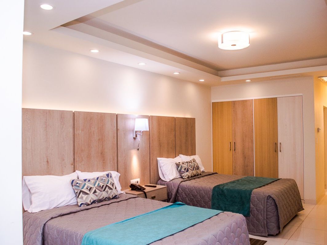 Habitación de La Siesta con dos camas y plafón iluminado