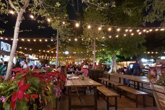 Parque La Ruina de noche, con mesas y luces